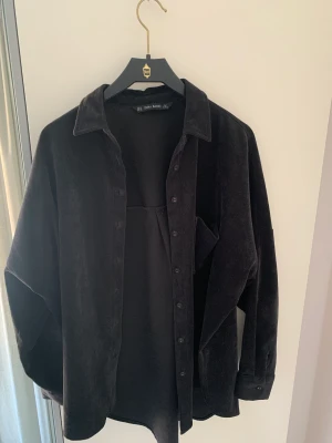 Manchesterskjorta - Manchesterskjorta från Zara i storlek 36. Tyvärr klippt bort lappen men misstänker bomull eller polyester. Svartare i verkligheten. Ingenting att anmärka på.