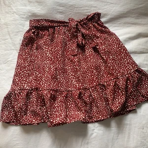 Vinröd prickig kjol - Detta är en ganska kort kjol som är jätte fin men nu har den blivit för liten för mig , den har en volang ner till och band vid midjan som man kan knyta (de är bara prydnad) jag vet inte vart den är ifrån eftersom det var ganska länge sen jag köpte den.