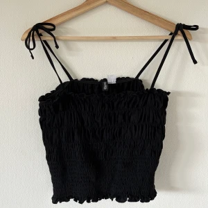 Smockad topp med rosetter - Säljer denna så söta smockade topp med rosetter💓 från hm, endast använd fåtal gånger