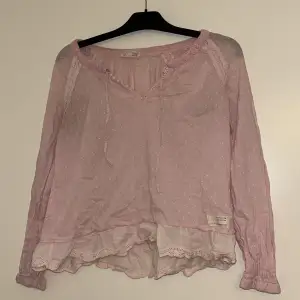 Rosa blus som är i använt skick försöker rensa ut bland kläder 