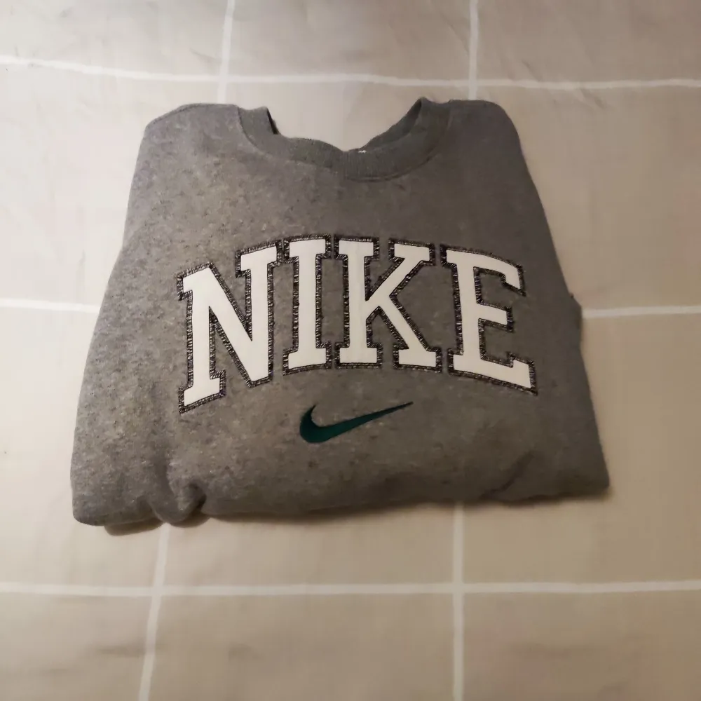 Nike Retro tröja i grå/vit färg, liten fläck i bakre ärmhålet men syns knappt. Tröjor & Koftor.