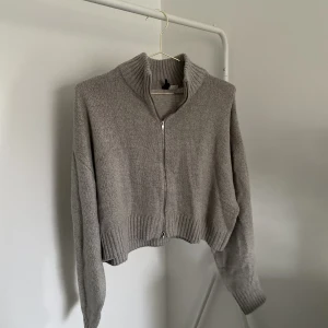 Grå stickad tröja  - En grå stickad tröja med dragkedja från H&M. Storlek M. 