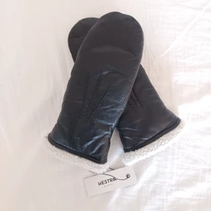 Hestra skinnvantar - Svarta tumvantar i lammskinn med lammullsfoder från Hestra. Använda ett fåtal gånger (kanske 5-6), väldigt bra skick, nära nyskick. Orginalpris 1299 kr. Storlek 6.5