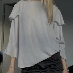 Glittrig blus - Säljer denna Trekvartsärm blus som är glittrig. Aldrig använd. Inte mina bilder.