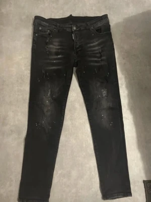 Riktigt feta dsquared2 jeans  - Säljer ett  par jeans med slitningar och distressed detaljer. Ena paret är svart med färgstänk 