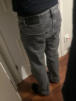 Grå loose fit jeans - Säljer ett par gråa loose fit jeans med raka ben. Jeansen har klassiska fem fickor och bälteshällor. Materialet är denim i 100% bomull och färgen är tvättad grå, vilket ger en cool vintagekänsla. Perfekta för en avslappnad och trendig stil. Den har waist 31 och längd 32. Jeansen är knappt använda. Skriv om ni undrar något. 