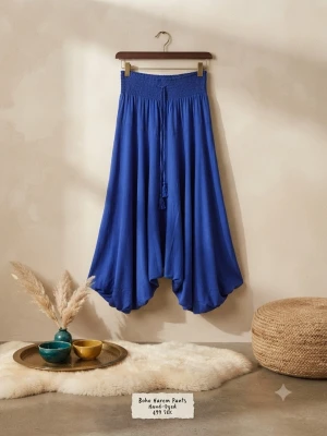 Blå boho harem leggings - Säljer ett par blå boho-inspirerade harem leggings med bred smock i midjan och lös, draperad passform. Byxorna har dekorativa knytband framtill och är tillverkade i ett mjukt, flowy material som ger en avslappnad vibe.