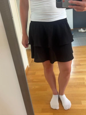 Svart volang kjol - Säljer en svart volang kjol med skönt material.