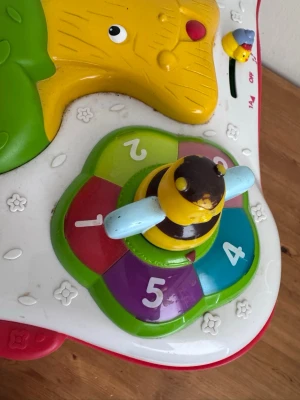 Färgglad aktivitetsleksak med djur - Rolig aktivitetsleksak i plast med färgglada detaljer, snurrande kugghjul och djurfigurer som bi, groda, fisk och lejon. Leksaken har siffror, olika former och knappar som stimulerar lek och lärande för små barn.