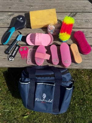 Fairfield ryktväska med borstar - Säljer en blå ryktväska från Fairfield fylld med olika borstar, hovkrats, mankam, svamp, gummisnoddar och ryktsten. Borstarna är i rosa, svart och färgglada nyanser. Perfekt för hästskötsel och att hålla utrustningen organiserad. Endast väskan 200kr och med borstar 300kr💕