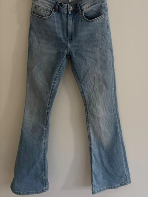 Ljusblå bootcut jeans - Säljer ett par ljusblå bootcut jeans med klassisk femficksmodell och normal midja. 