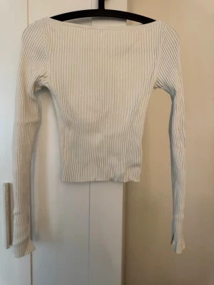Vit ribbad långärmad topp H&M - Säljer en vit ribbad långärmad topp från H&M i storlek XS. Toppen har en tight passform och är tillverkad i mjukt material som sitter snyggt på kroppen. Perfekt att styla med jeans eller kjol för en clean look.