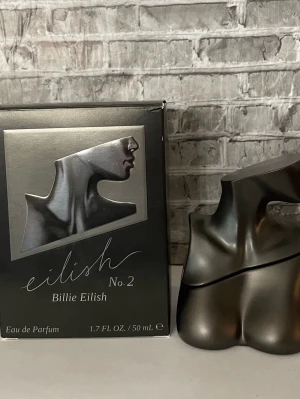 Eilish No. 2 Eau de Parfum 50 ml - Eilish No. 2 från Billie Eilish är en Eau de Parfum i en unik, metallisk flaska formad som en byst. Flaskan har en mörk, elegant finish och rymmer 50 ml.  Se bilder för mängd kvar och noter 