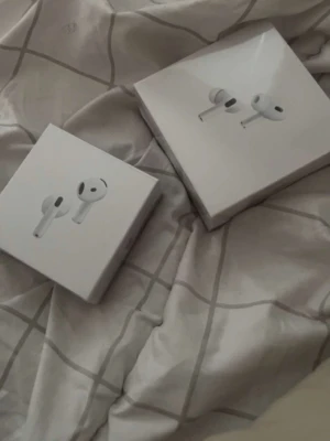 Apple AirPods 4 med AppleCare+ - Säljer ett par Apple AirPods 4 i vitt, trådlösa hörlurar med stilren design och laddningsetui. Kommer i originalförpackning och har AppleCare+ till januari 2027. Perfekta för musik, samtal och träning med smidig anslutning till Apple-enheter.(EJ ÄKTA MEN FUNGERAR EXAKT LIKADANT)