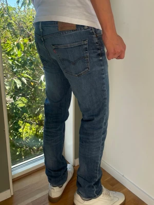 Levis 511 Jeans Vintage - Levis 511. Raka jeans. Färg: Blå med lätta fades | Modell: 511 | Storlek: W34 L34 | Vintage Premium Jeans. Passar perfekt på killen i bilden som är 189 cm. Lite slitna i grenen men inget som påverkas vid användning. Mått: A: 43 cm B: 108 cm C: 18 cm D: 27 cm Tveka inte att höra av dig minsta fråga eller fundering! Skickas snabbt!