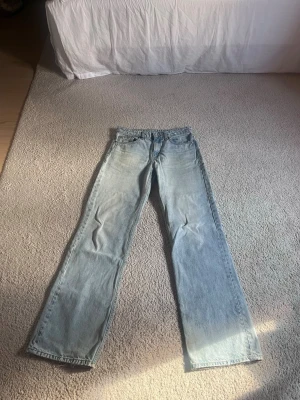 Ljusblå low waist jeans från Zara - Säljer ett par ljusblå jeans från Zara i low waist med rak passform och klassisk femficksdesign. Jeansen har en avslappnad vibe och är tillverkade i bomull med snygg tvättad look. Perfekta för dig som gillar en enkel och stilren stil.