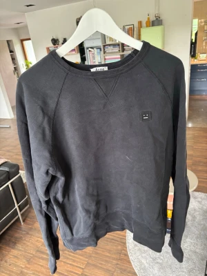 Acne Studios crewneck - Svart crewneck från Acne Studios med klassisk rund halsringning och det ikoniska Face-logotypen på bröstet. Tröjan har inga defekter eller liknande och är i väldigt bra skick. Tröjan är M och sitter som M i mitt tycke. Hör av er om ni har några frågor!