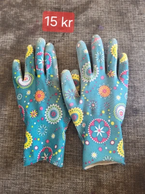 Trädgårds handskar  - Färgglada handskar i turkos med blommigt mönster i rosa, gul, vit och blå. Handskarna är tunna och smidiga, perfekta för dig som vill ha något unikt och lekfullt till din outfit. Materialet känns syntetiskt och de har en tajt passform.