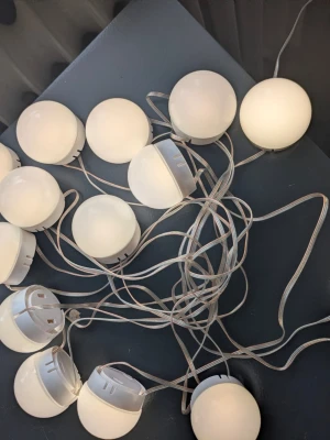 Sminkspegel lampor  - Sminkspegelbelysning med 10 LED-lampor. Lamporna har en USB-anslutning för strömförsörjning. Ljusstyrkan är justerbar och det finns tre olika färglägen att välja mellan. Lamporna är 5 cm i diameter och avståndet mellan varje lampa är 40 cm. Den totala längden på sladden är 5.1 meter. Materialet är PC-överdrag och plastbas. Effekt: 8W. Oanvända 
