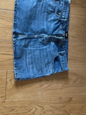Blå jeanskjol i kort modell - Säljer en klassisk blå jeanskjol i kort modell