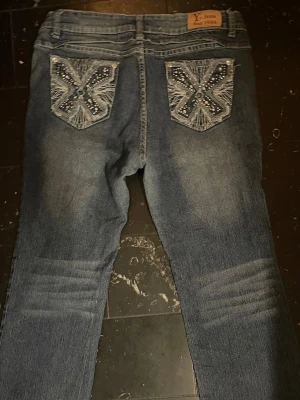 Y2K Jeans - Märke & Modell: Y-Jeans Storlek: 13 (Passar S/M) Passform: Tighta, bootcut Skick: 9,5/10 Om plagget: Ett par svinsnygga jeans i mörkblå färg med unik design på bakfickor och som sitter skitsnyggt. Info: 100% äkta | Postas inom 24h | Skriv vid frågor eller önskemål om fler bilder! 👖