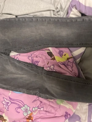 Grå jeans från Diesel - Säljer ett par gråa jeans från Diesel med snygg tvättad look och röda sömmar på insidan. Klassisk femficksmodell och raka ben. Perfekta för dig som vill ha en avslappnad men ändå stilren vibe.