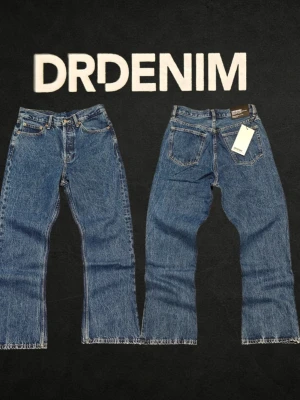 DrDenim Kit Bootcut Jeans W28/L30 Blå - Säljer ett par nya klassiska blå jeans från Dr Denim med rak passform och råa bootcut kanter vid benslut. Jeansen har fem fickor, knappgylf och är tillverkade i slitstark denim. ❌ Passformsbilder skickas ej. Se mått! 💬 Prisförslag välkomnas. 🚫 Rökfritt & djurfritt hem. 📦 Skickas inom 24 timmar. 😱 Smutsfläckar kan förekomma