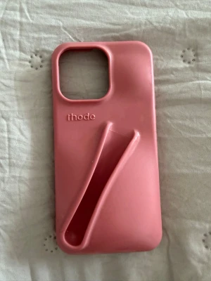 Rhode Lip Case - Så snyggt rosa/gammelrosa Rhode Lip Case för iPhone 14 Pro Max / 15 Pro Max. Inbyggd hållare för Rhode Peptide Lip Treatment/Lip Tint. Har tecken på användning, men är fortfarande i fint skick💞🌸.  ‼️Läpprodukt ingår ej. 