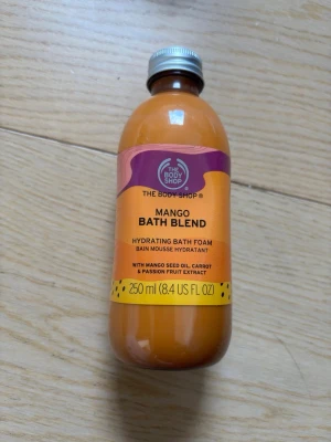 Mango Bath Blend från The Body Shop - Mango Bath Blend från The Body Shop är ett återfuktande badskum med mango, morotsfröolja och passionsfruktextrakt. Kommer i en orange plastflaska på 250 ml med skruvlock. Ger ett fruktigt och lyxigt bad. Aldrig använt då jag inte äger ett badkar.