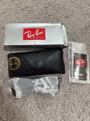 Ray-Ban svarta Wayfarer solglasögon - Klassiska svarta Wayfarer solglasögon från Ray-Ban med gröna glas. Snygg och tidlös design med Ray-Ban-logga på linsen. Kommer med originalfodral, putsduk och förpackning. Perfekta för soliga dagar och ger en cool vibe.