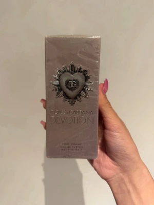 Dolce & Gabbana Devotion Pour Homme (Eau de Parfum) 100 ml -  Dolce & Gabbana Devotion Pour Homme (Eau de Parfum) 100 ml ✨ Helt ny och oöppnad/inplastad parfym i originalförpackning! Perfekt som present eller till dig själv.  Doftnoter: Fräsch citron, fylligt kaffe och varm patchouli – en riktigt stilren och manlig doft!  Volym: 100 ml  Koncentration: Eau de Parfum (håller länge på huden)  Skick: Oöppnad  ( bara plasten öppnades en gång) med plasten kvar 📦 Snabb frakt! Fraktar inom 24 timmar efter köp!