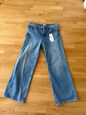 Blå raka jeans från Gina Tricot - Säljer ett par ljusblå jeans från Gina Tricot med raka, vida ben. Aldrig använda pga för små för mig