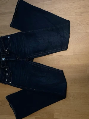 Mörkblå True Religion jeans bootcut - Snygga mörkblå jeans från True Religion med bootcut-modell. Inte använda så mycket, så bra skick . Perfekta för dig som gillar en avslappnad men trendig look.