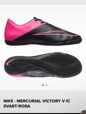 Nike Mercurial Victory V IC svart/rosa - Snygga Nike Mercurial Victory V IC fotbollsskor i svart och rosa med låg profil och slimmad design. Skorna har syntetöverdel och platt yttersula som passar perfekt för spel på inomhusplaner. Ikonisk Nike-logga i rosa längs sidan och på tån.