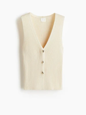 Ribbad beige väst med knappar - Stilren ribbad väst i beige med djup v-ringning och tre dekorativa knappar framtill. Västen har en smickrande passform och är perfekt att styla över en t-shirt eller skjorta för en trendig look.