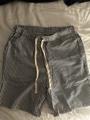 Randiga sommar shorts - Säljer ett par randiga mörkblåa shorts med bekväm resårmidja och snörning framtill. Aldrig använda så i ny skick. Säljer dem för jag ej vill ha dem längre. Säljs för 250kr. Kontakta mig om du har frågor.