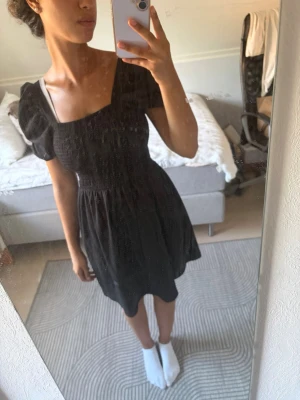 Svart puffärmad klänning H&M - Trendig svart klänning från H&M med puffärmar och smockad överdel. Säljer pga ingen använding<33