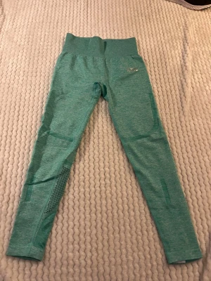 Gröna seamless leggings från ICANIWILL - Snygga gröna seamless leggings från ICANIWILL med hög midja och diskret logga på höften. Materialet är stretchigt och har ventilerande meshdetaljer längs benen. Perfekta för träning eller chill dagar.