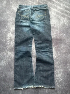 Whiskered-tvättade bootcutjeans för kvinnor från 2000-talet i storlek W29 L30 - Mått: Midja: 39 cm Benslut: 23 cm Lår: 28 cm Totallängd: 100 cm  W & L är uppskattade utifrån måtten.  Spara på priset och frakten genom att sätta ihop ett paket 7-227