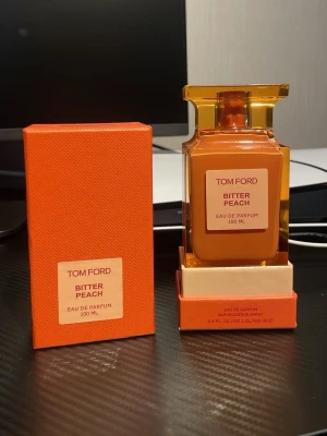 Tom Ford Bitter Peach Eau de Parfum - Tom Ford Bitter Peach Eau de Parfum 100 ml i en lyxig, fyrkantig glasflaska med orange och guldiga detaljer. Kommer med matchande orange kartong. Doften är känd för sina fruktiga och sensuella noter, perfekt för dig som vill sticka ut. Jag har tyvärr inte kvittot på den fick den som en present men kan skicka flera bilder
