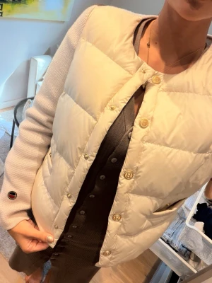 Beige busnel cardigan  - Snygg beige cardiganjacka med quiltad front och stickade ärmar. Jackan har guldfärgade knappar och rund halsringning. Detalj med liten patch på ärmen. Perfekt för lager på lager och ger en trendig look. Använd 2-3 gånger, tröttnat på den och använder den inte. Nypris 4500 mitt pris 3000 priset går att diskutera vid snabb affär 