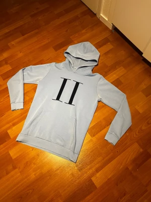 Ljusblå les deux hoodie xs  - Säljer en les deux hoodie i storlek xs. Fast Passformen på hoodien käns mer som en S hoodie en xs. Säljer hoodien eftersom den är lite stor för mig köpte hoodien här på Plick och ångra mig och darför säljer den. Hoodien har en defekt där knappen på luvan är lite sliten. 