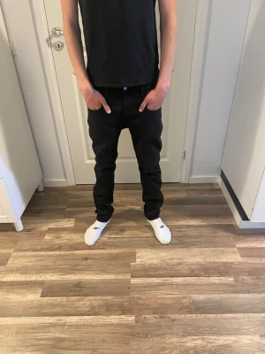 Svarta slim replay hyperflex - Säljer ett par svarta slim fit jeans med klassisk femficksmodell och normal midja. Jeansen har raka ben och diskreta sömmar, perfekta till en avslappnad stil. Materialet är mjukt och stretchigt för extra komfort.