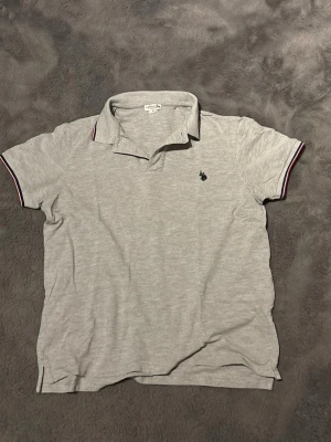 US polo assasin - Detta är en riktigt fett polo från polo assn som har inga defekter och har använts få gånger. Storlek M färg grå