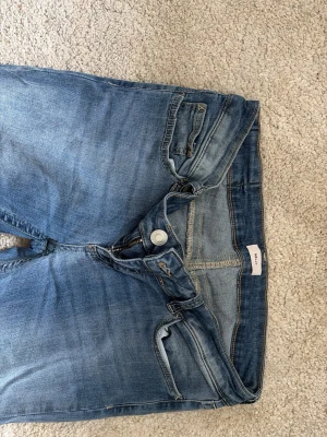 Blå slitna jeans med raka ben - Säljer ett par blåa jeans.  Jeansen har klassiska fem fickor, ljus tvätt och kontrastsömmar. Passar perfekt till en avslappnad stil och är gjorda i mjukt denimtyg. köpta för 700❣️