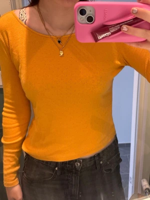 Gul långärmad topp med båtringning - Säljer en gul långärmad topp med båtringning och figurnära passform. Toppen är ribbad och har en lätt stretchig känsla, perfekt att matcha med jeans eller kjol. Materialet ser mjukt och bekvämt ut, och färgen är riktigt poppig och trendig. 
