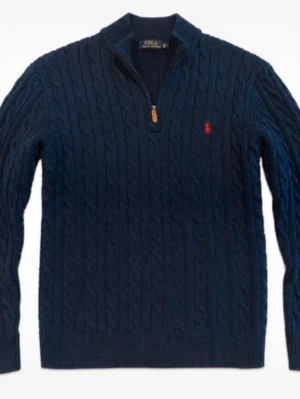 Mörkblå kabelstickad tröja Polo Ralph Lauren - Mörkblå kabelstickad tröja från Polo Ralph Lauren med halv dragkedja och röd broderad logga på bröstet. Tröjan har ribbade muddar och hög krage, perfekt för lager på lager. Klassisk och tidlös design i mjukt material.