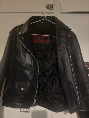 Bebgagnad mc jacka äkta läder  - Säljer min riktigt snygga och klassisk mc-/bikerjacka i äkta svart läder från märket Geldman. Jackan  inslag av lite  vintage-stuket med kraftiga silvriga dragkedjor, snygga detaljer och ett quiltat innerfoder Sparsamt använd ,  bra skick