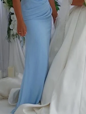 Ljusblå långklänning med drapering - Elegant ljusblå långklänning med draperad överdel och figurnära passform. Klänningen har en mjuk, slät yta och är ärmlös, perfekt för speciella tillfällen.