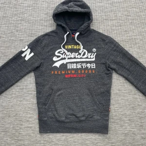 Vintage superdry hoodie - Säljer nu denna riktigt feta vintage superdry hoodie!👏 Skick: 8.5/10🌟- Lite sprucket tryck men annars väldigt bra skick🙌 Storlek: S🤩 Hör gärna av er vid frågor eller funderingar!🤗